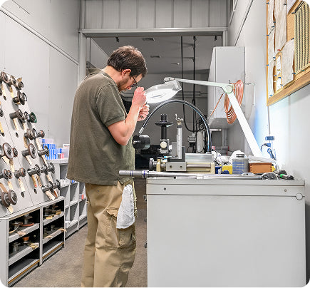 Technician working on precision tool equipment in a modern workshop
